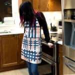 Apron of Jute Impossible design on woman in kitchen by Hem and Tassel