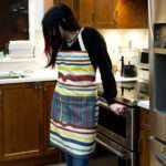 Apron of Not straight Clay design on woman in kitchen by Hem and Tassel