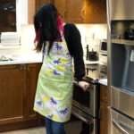 Apron of Pollen Up Mint design on woman in kitchen by Hem and Tassel