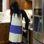 Apron of Shy dragonflies Yellow design on woman in kitchen by Hem And Tassel