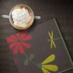 shy dragonfly dinner napkin on table with coffee from hem and tassel