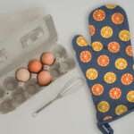 faded orange oven mitt with a tray of eggs from hem and tassel