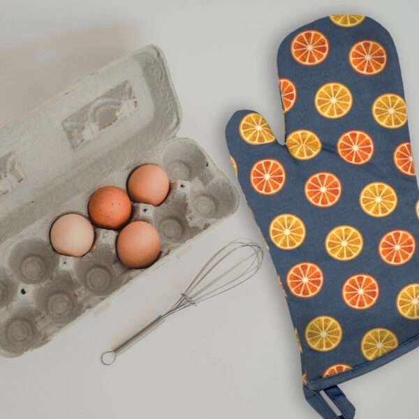 faded orange oven mitt with a tray of eggs from hem and tassel