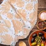 MONSTER AH BUFF tea towel in kitchen with olives