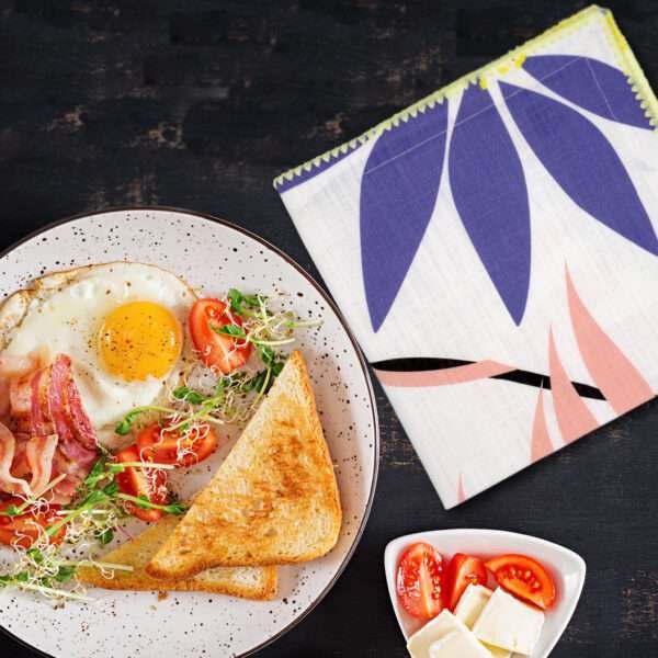 pollen up dinner napkin on table with breakfast from hem and tassel