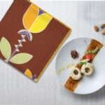 art deco lip tulip design dinner napkin on table with desert plate