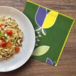 art deco lip tulip design dinner napkin with pasta meal on table from hem and tassel