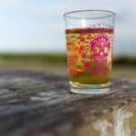 7oz Skull glass pink on a park table with juice inside