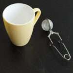 Clip style ball tea infuser beside icon mug yellow by dte from hem and tassel