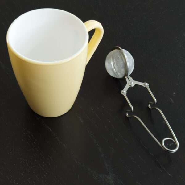 Clip style ball tea infuser beside icon mug yellow by dte from hem and tassel